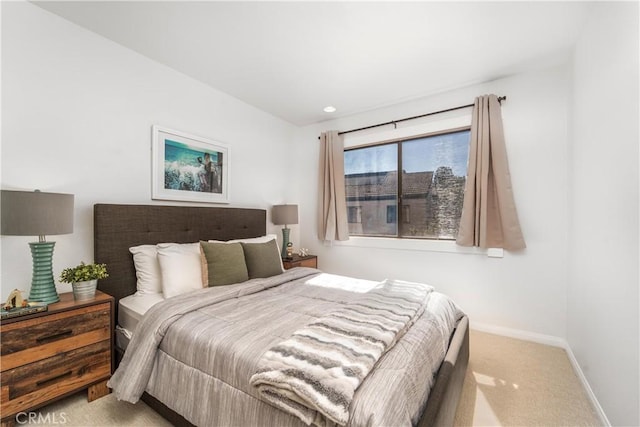 bedroom featuring light carpet and baseboards