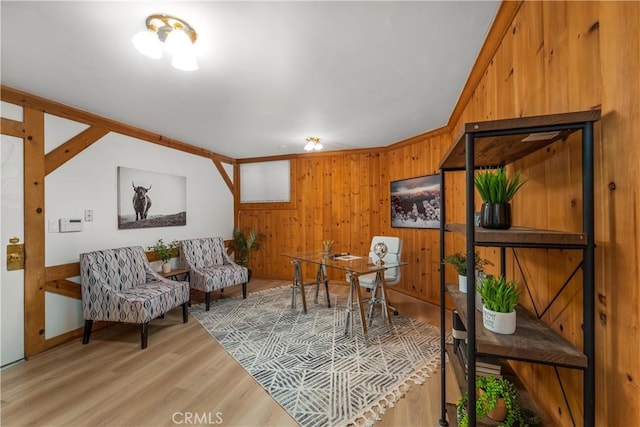 sitting room with wood walls and light wood-type flooring