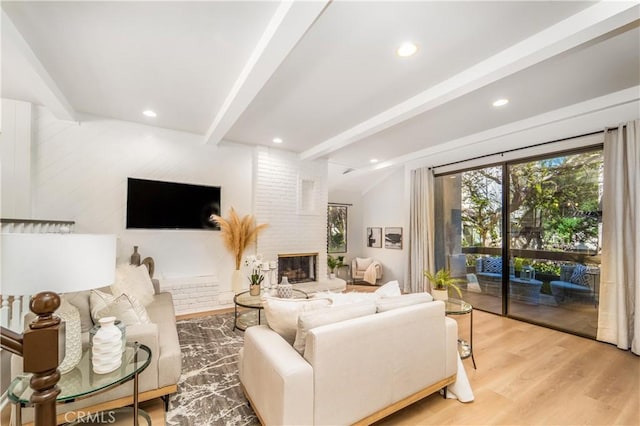 living room with vaulted ceiling with beams, light wood-style floors, a fireplace, and recessed lighting