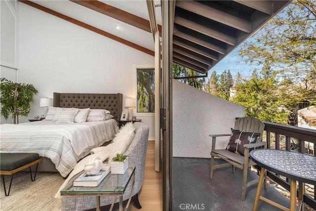 bedroom with vaulted ceiling with beams and wood finished floors