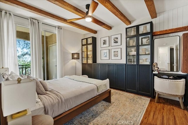 bedroom featuring beamed ceiling and wood finished floors