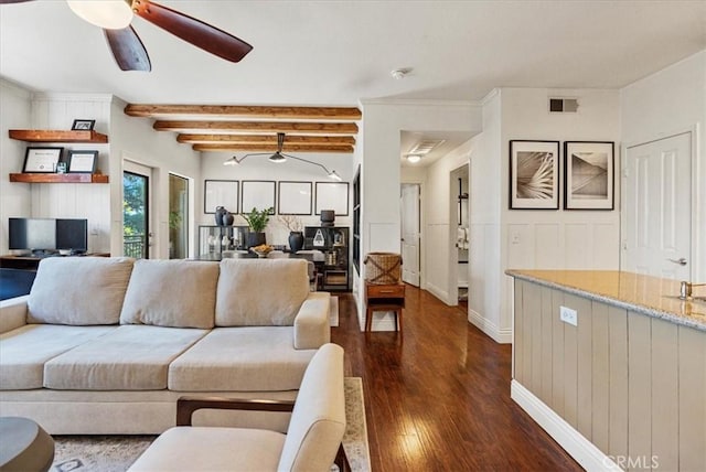 living area featuring dark wood-style flooring, visible vents, baseboards, a ceiling fan, and beam ceiling