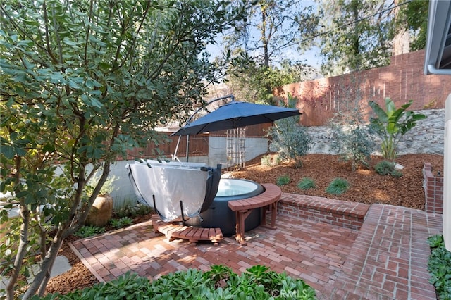 view of patio / terrace with a jacuzzi and a fenced backyard