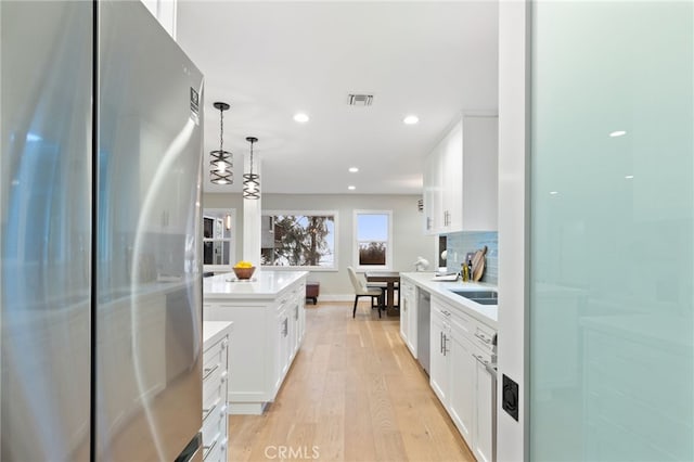 kitchen featuring visible vents, stainless steel appliances, light countertops, and white cabinetry