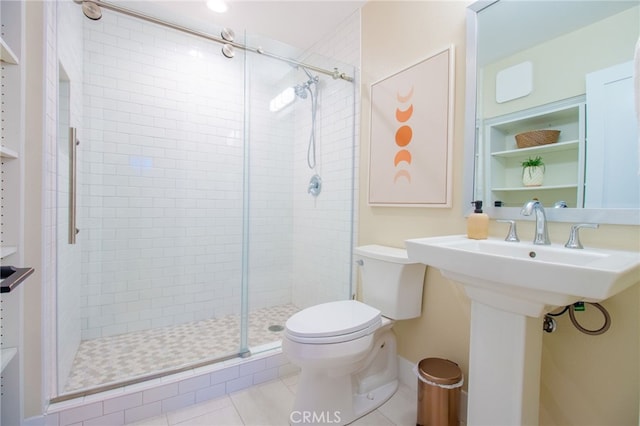 bathroom featuring a shower stall, toilet, and tile patterned floors