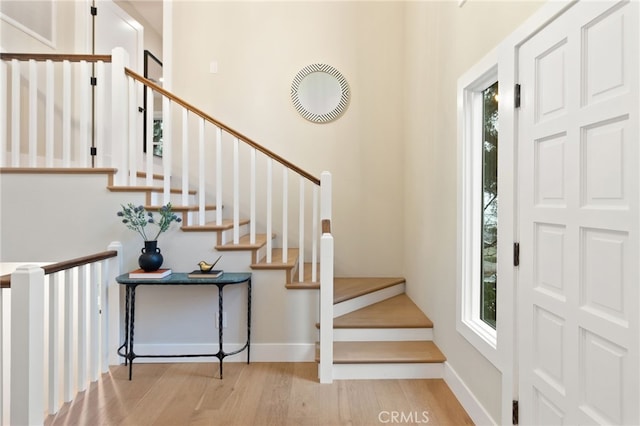 entrance foyer featuring baseboards, stairs, and light wood-style floors