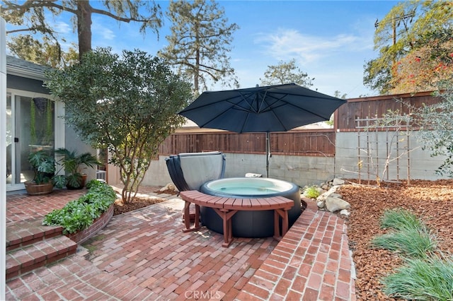 view of patio / terrace with a fenced backyard and a hot tub