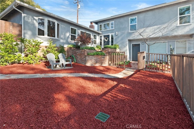 rear view of property with fence and stucco siding