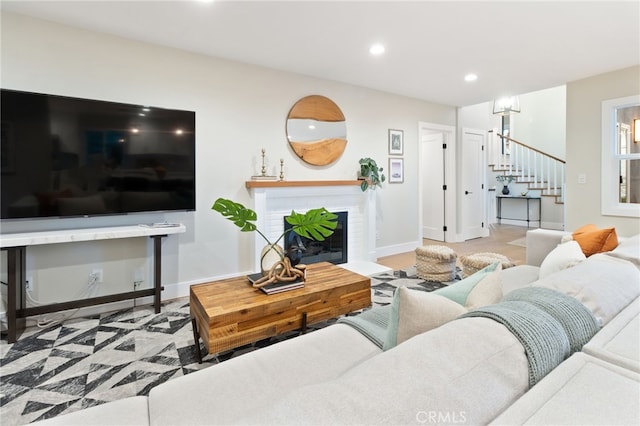 living area featuring recessed lighting, a fireplace, stairway, and baseboards