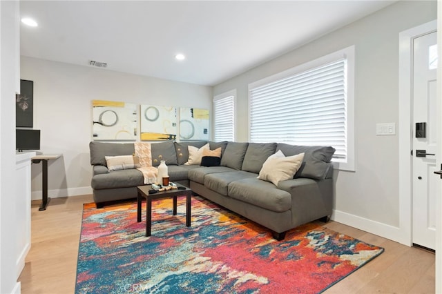 living area with baseboards, light wood-type flooring, visible vents, and recessed lighting