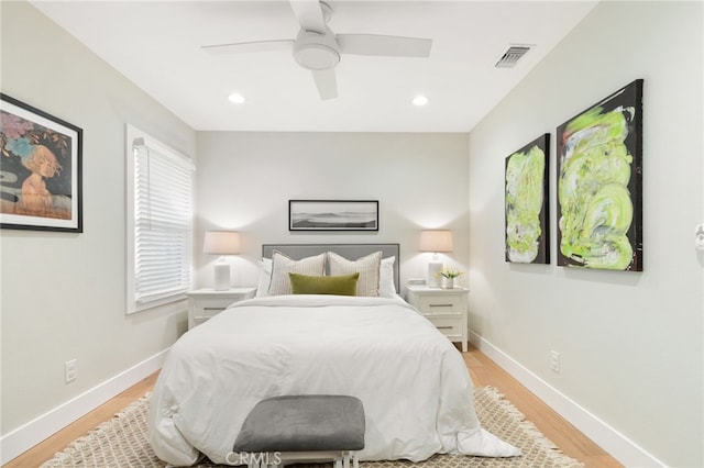 bedroom with baseboards, visible vents, light wood-style flooring, and a ceiling fan