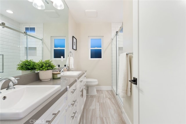 bathroom with a sink, toilet, and a shower stall