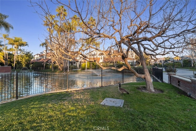 view of yard featuring a water view and fence