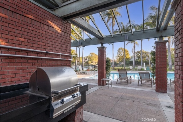 view of patio featuring a lanai, area for grilling, and a community pool