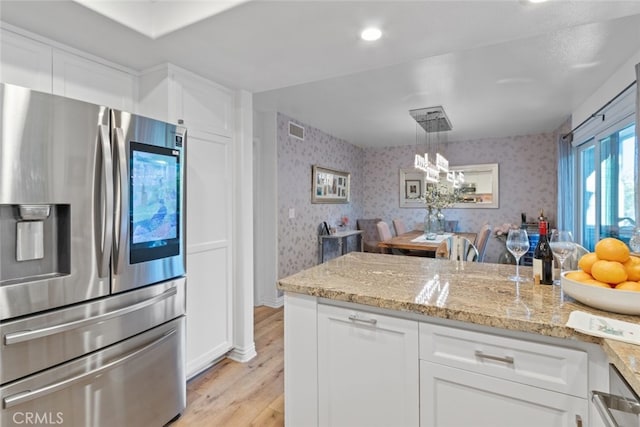 kitchen featuring wallpapered walls, white cabinetry, visible vents, and stainless steel fridge with ice dispenser