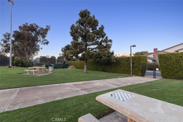 view of home's community with a yard and fence