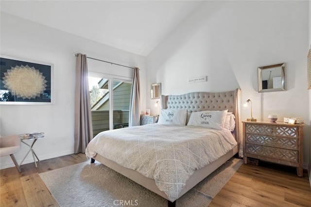 bedroom with high vaulted ceiling, access to outside, baseboards, and wood finished floors