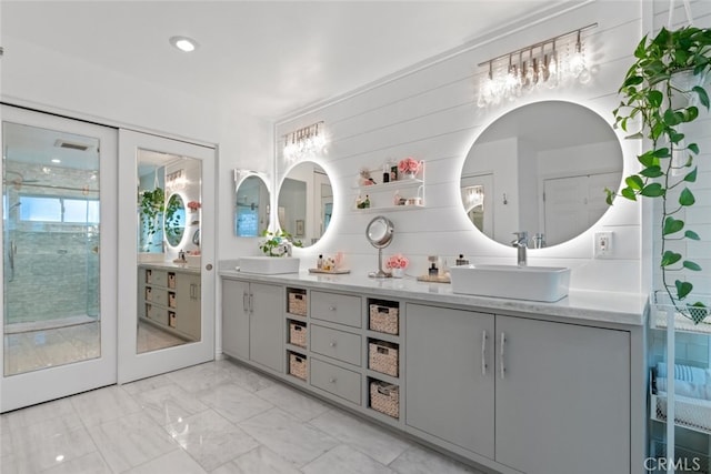 full bathroom featuring marble finish floor, a sink, and double vanity