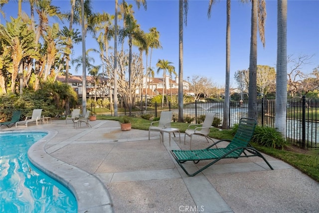 view of property's community featuring a patio, a swimming pool, and fence