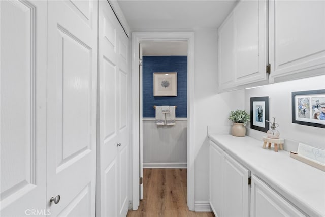 hallway featuring light wood-style floors and wainscoting