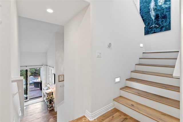 staircase featuring recessed lighting, wood finished floors, and baseboards