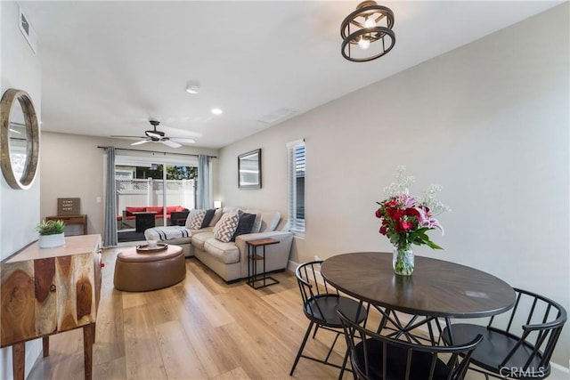 living room with light wood finished floors, baseboards, visible vents, and a ceiling fan