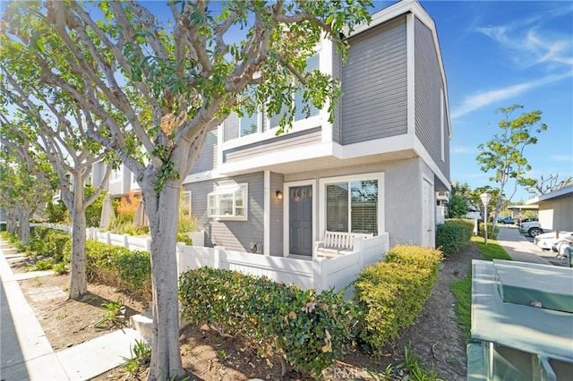 view of front of property with a fenced front yard and stucco siding