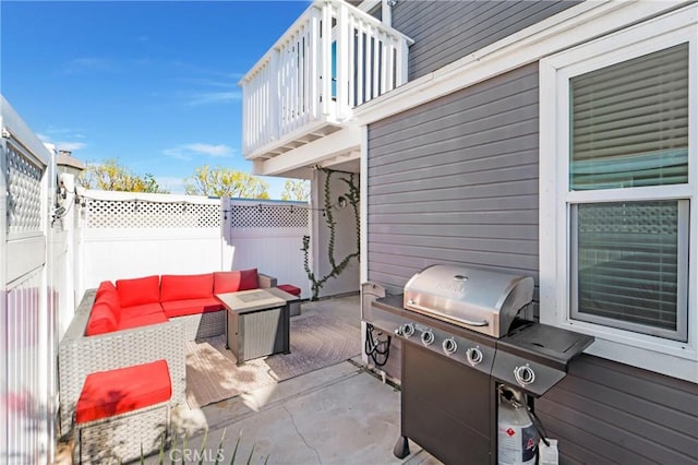 view of patio with a balcony, a grill, fence, and an outdoor hangout area