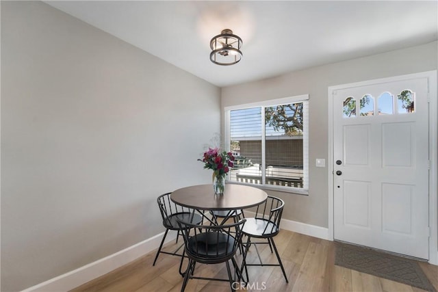 dining space featuring light wood-style floors and baseboards