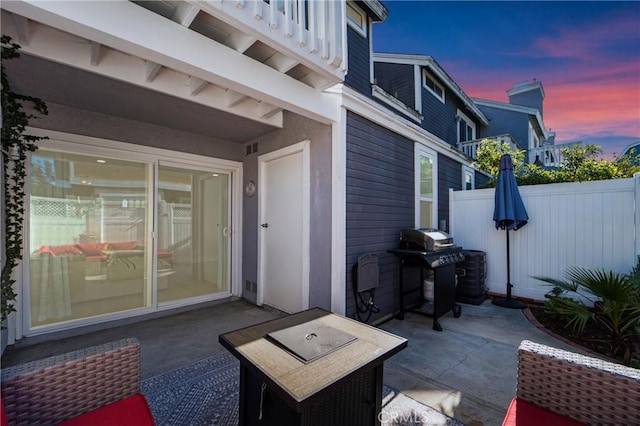 patio terrace at dusk with area for grilling and fence