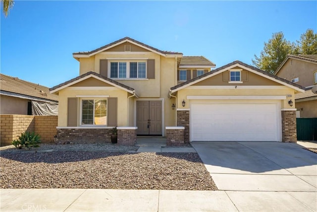 view of front facade featuring a garage, concrete driveway, brick siding, and stucco siding