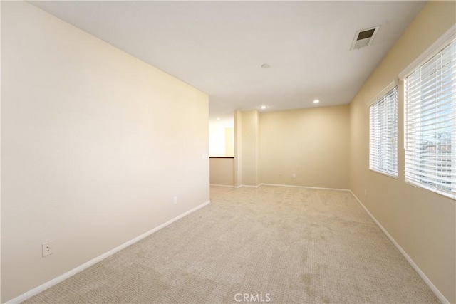 spare room featuring recessed lighting, visible vents, light carpet, and baseboards