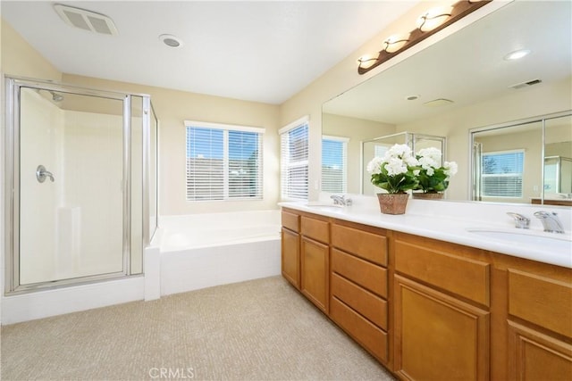 full bathroom featuring double vanity, visible vents, a garden tub, a shower stall, and a sink