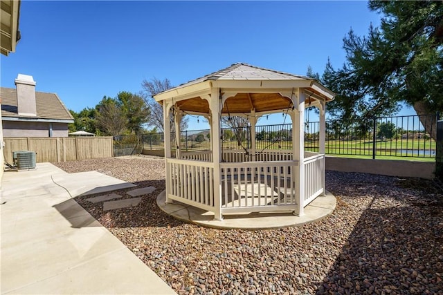 view of yard with central air condition unit, a fenced backyard, and a gazebo