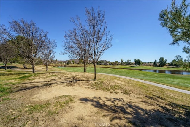 surrounding community with a water view and a yard