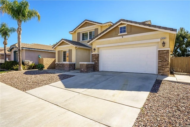 craftsman inspired home with an attached garage, brick siding, fence, concrete driveway, and stucco siding