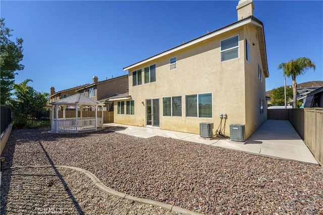 back of property with a patio, a fenced backyard, central AC, a gazebo, and stucco siding