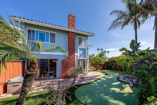 back of property with a fenced backyard and a chimney