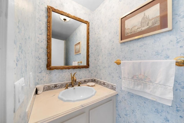 bathroom with vanity and wallpapered walls