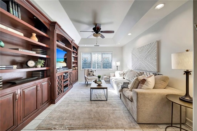 living area with a raised ceiling, a ceiling fan, and recessed lighting