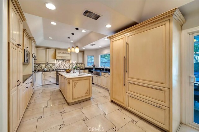 kitchen featuring a sink, cream cabinets, recessed lighting, and visible vents