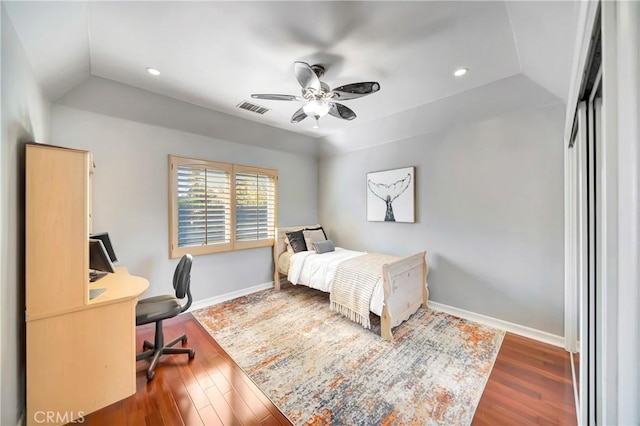 bedroom featuring lofted ceiling, visible vents, baseboards, and wood finished floors