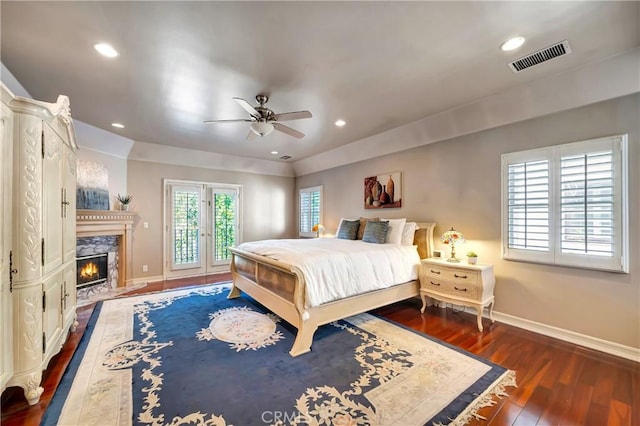 bedroom with baseboards, access to outside, visible vents, and wood finished floors