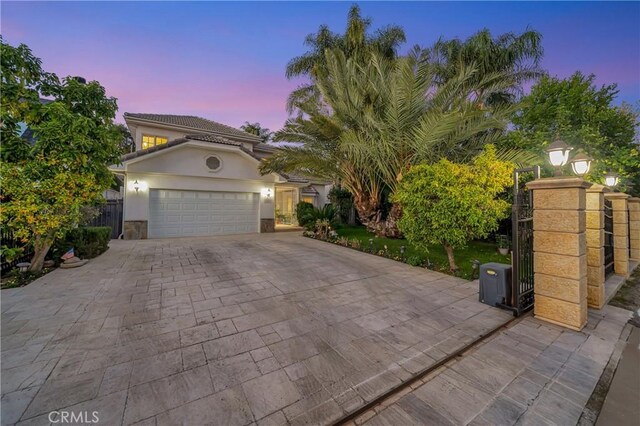 view of front of house with an attached garage, stucco siding, and driveway