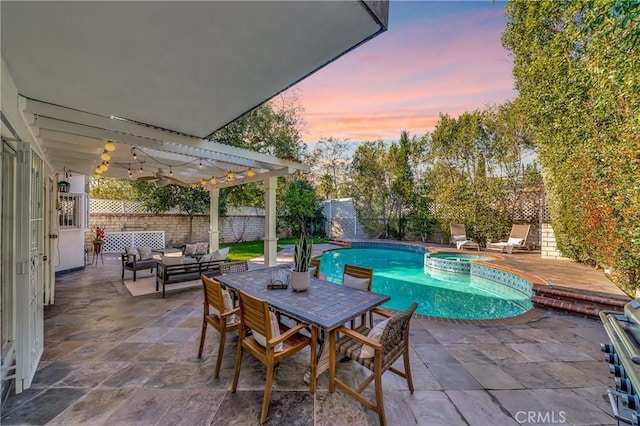 pool at dusk with a patio, a fenced backyard, a pool with connected hot tub, an outdoor living space, and a pergola