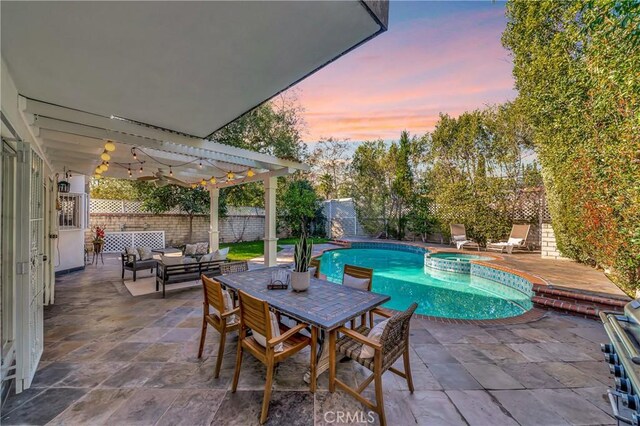pool at dusk with outdoor lounge area, a pergola, a patio, a fenced backyard, and a pool with connected hot tub