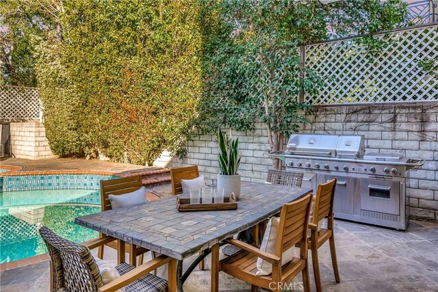 view of patio / terrace with outdoor dining area, fence, a fenced in pool, and a grill