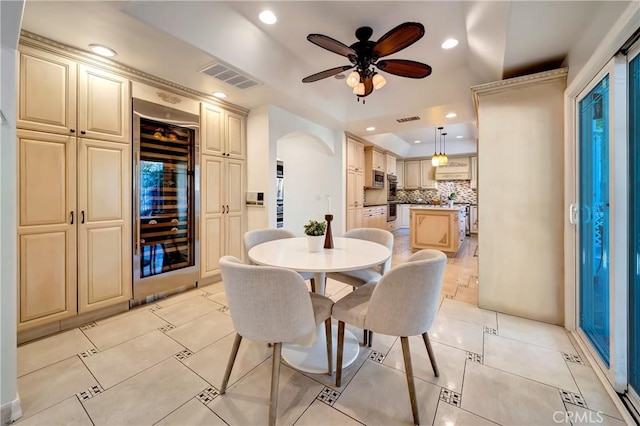 dining room featuring wine cooler, visible vents, arched walkways, and recessed lighting