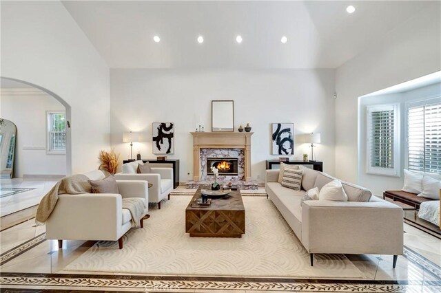 living area featuring recessed lighting, arched walkways, high vaulted ceiling, and a wealth of natural light