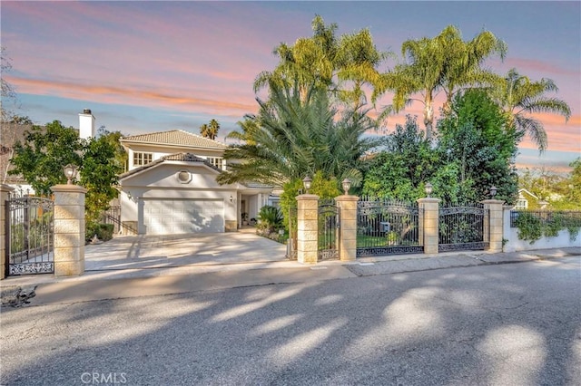 mediterranean / spanish-style house featuring a gate, fence, driveway, and an attached garage